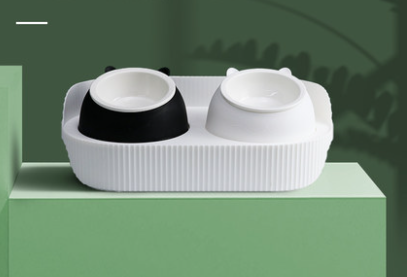 Two CJdrop ceramic food and water bowl stations for cats sitting on top of a green cube.