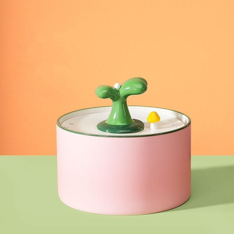 a green and yellow object sitting on top of a pink container