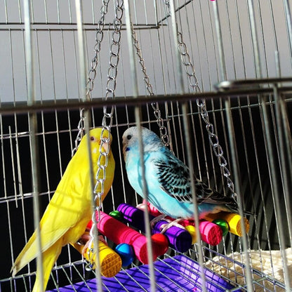 two parakeets sitting in a cage with toys