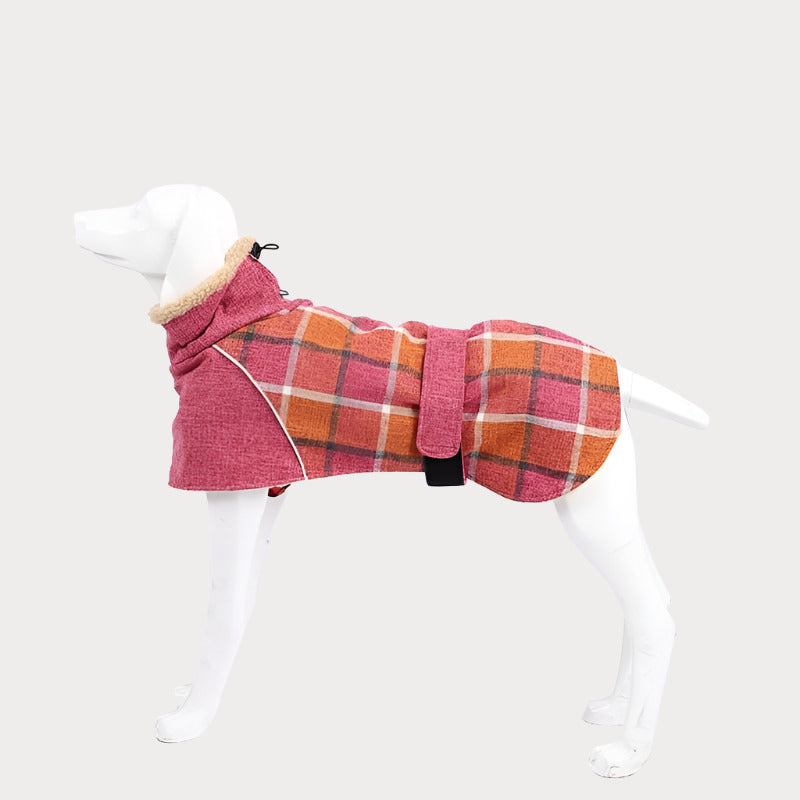 a white dog wearing a red and orange plaid coat